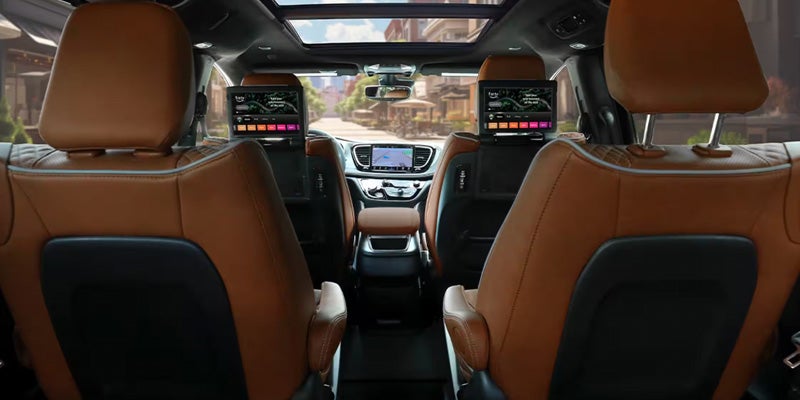 Chrysler Pacifica cabin with brown leather seats and seatback entertainment screens.