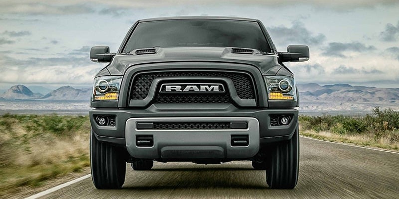 Front view of a Ram pickup truck driving on an open road.